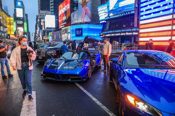 Fancy sports cars are seen on Broadway in Times Square